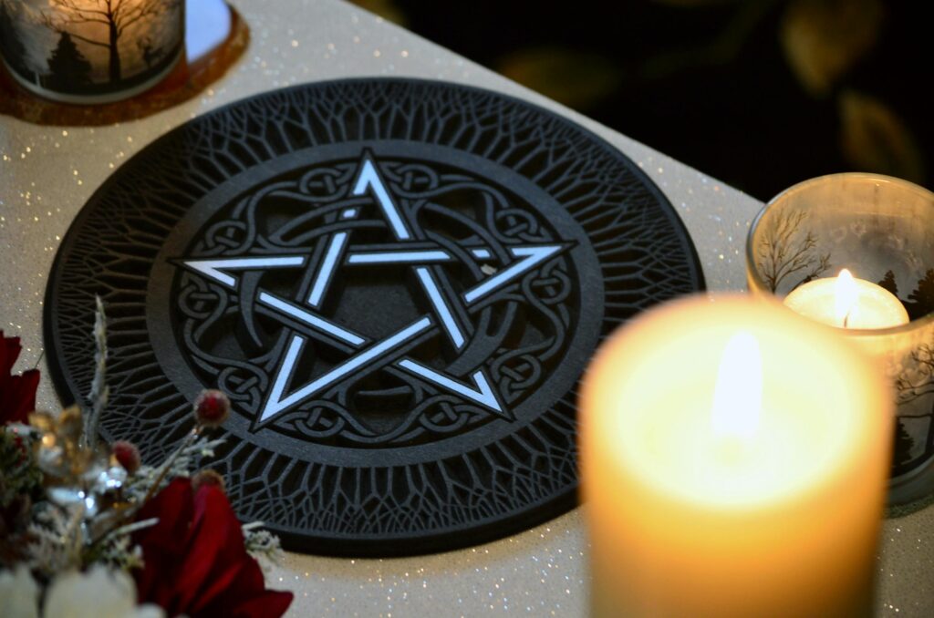 pexels-photo-6154211-6154211 A mystical pentacle on a decorated altar under candlelight, symbolizing witchcraft practices.