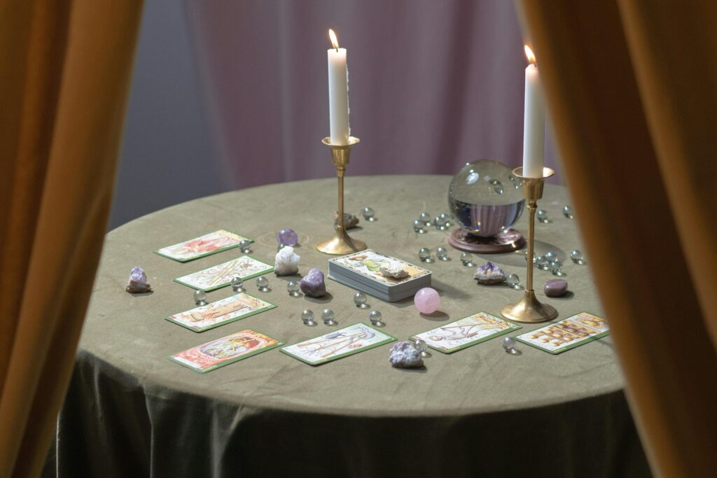 pexels-photo-7179792-7179792 A magical tarot reading table set with lit candles, crystals, and tarot cards suggesting mysticism.