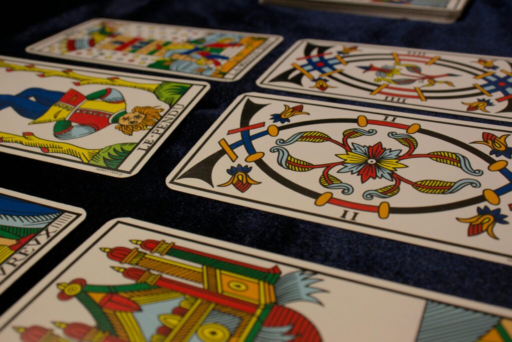 Close-up view of beautifully illustrated tarot cards arranged on a dark surface.
